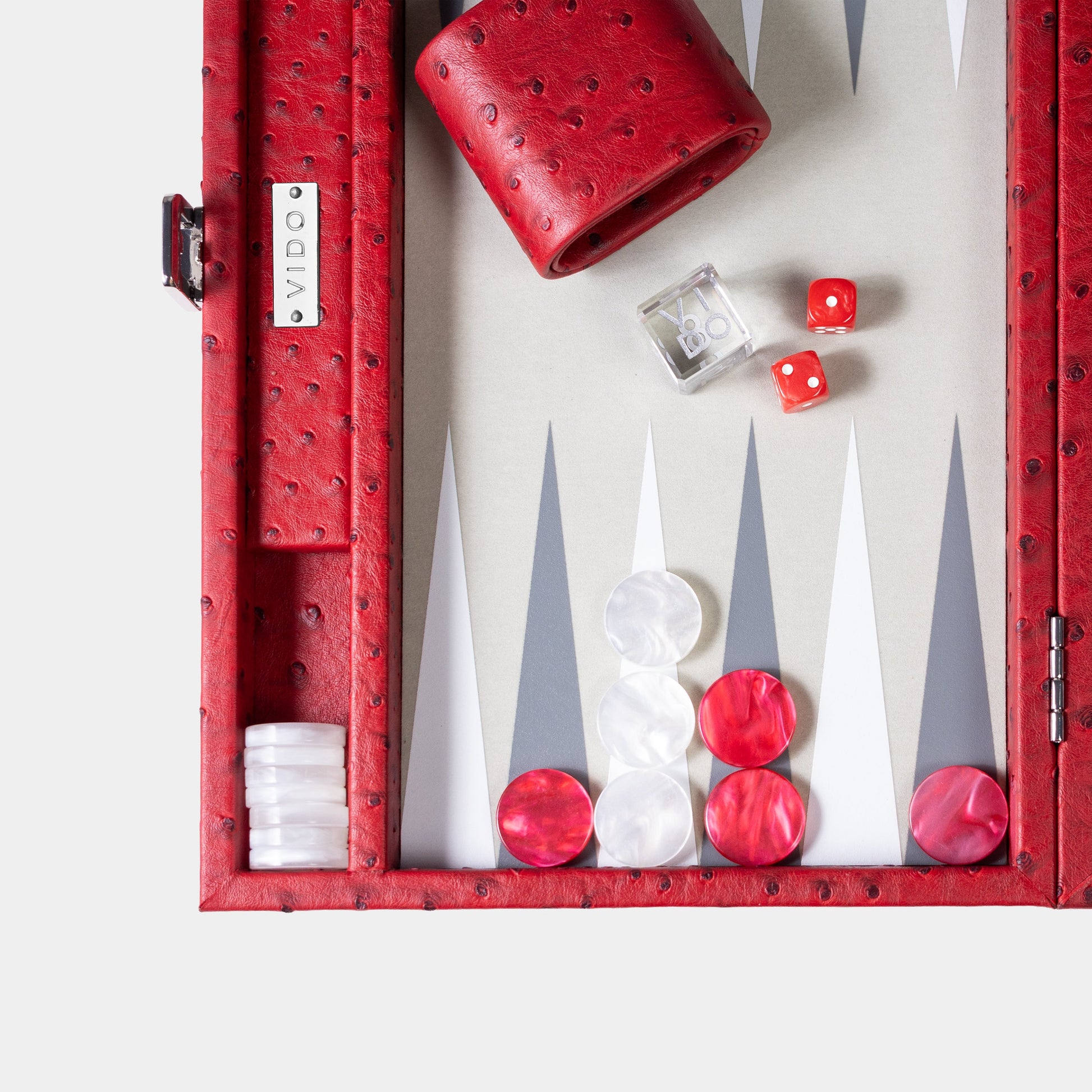 Backgammon set with red and white pieces in a red case on a white background by VIDO